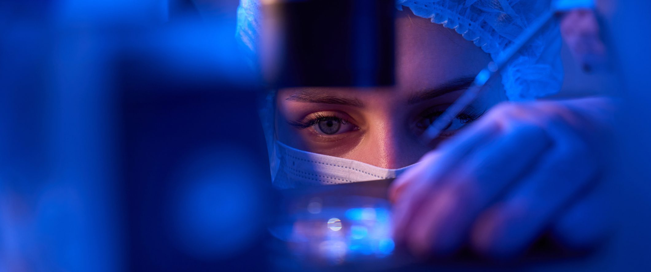 Experienced female scientist preparing specimens for microscopic examination