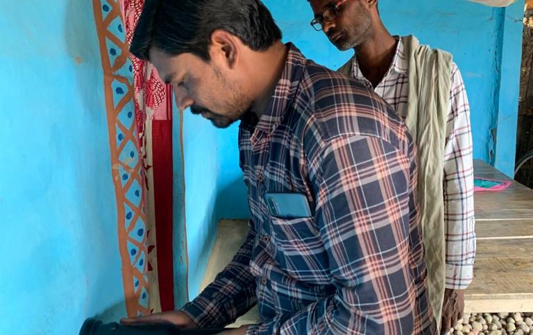 Sensor technology be used by a man in india to monitor insecticide sprayed on a blue wall