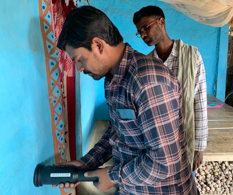 Sensor technology be used by a man in india to monitor insecticide sprayed on a blue wall